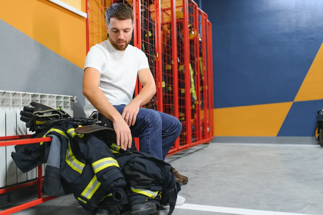 fireman changing clothes and fastening his helmet exercise concept